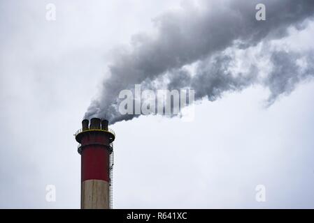 Fábrica de chimeneas humeantes contaminando el medio ambiente y el aire. Foto de stock