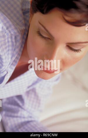 Retrato, Innenraum, Nahaufnahme, junge Frau mit kurzen braunen Haaren und braunen Augen im-weiss Pijama karierten hellblau Foto de stock