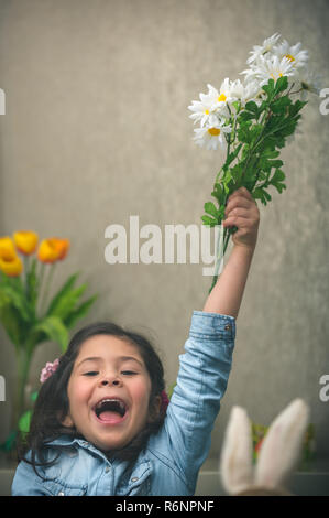 Emocionada niña con flores. Foto de stock