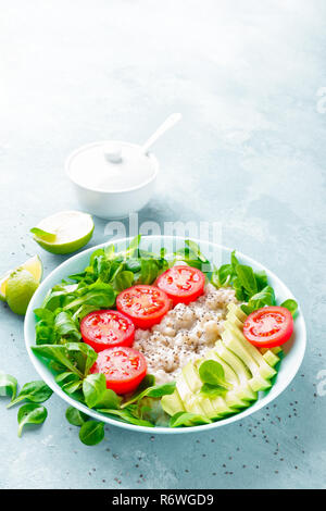Gachas de avena con aguacate y ensalada de verduras de tomates frescos y lechuga. Dieta saludable desayuno Foto de stock