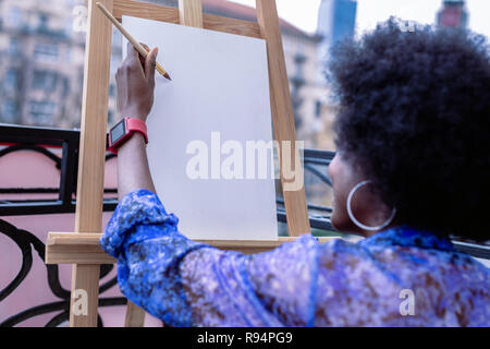 Artista afroamericano vestidos de rojo reloj inteligente trabajando fuera Foto de stock