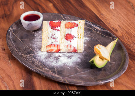Tarta de fresa en la placa de mármol sobre la mesa de madera Foto de stock