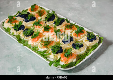 Huevos rellenos con salmón y caviar decorado con perejil y eneldo. Parte alimentos