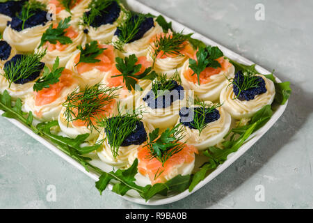 Huevos rellenos con salmón y caviar decorado con perejil y eneldo. Parte alimentos
