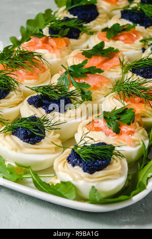 Huevos rellenos con salmón y caviar decorado con perejil y eneldo. Parte alimentos