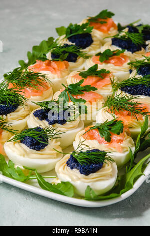 Huevos rellenos con salmón y caviar decorado con perejil y eneldo. Parte alimentos