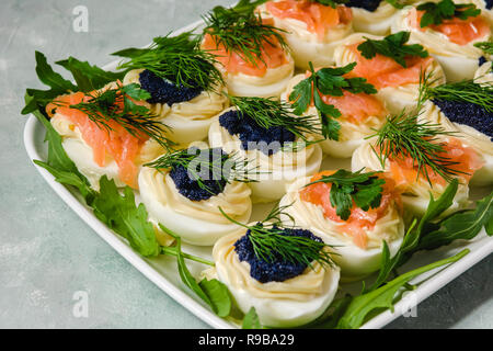Huevos rellenos con salmón y caviar decorado con perejil y eneldo. Parte alimentos