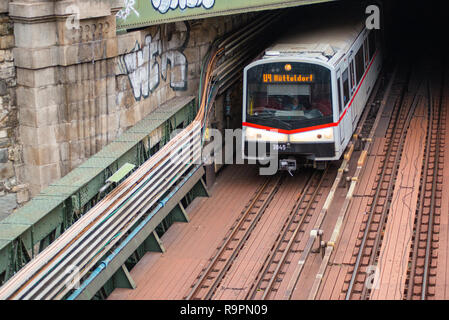 El metro U-Bahn sale de un túnel y pasa bajo el puente Zollamtssteg cruzando el río en Viena, Austria. Foto de stock