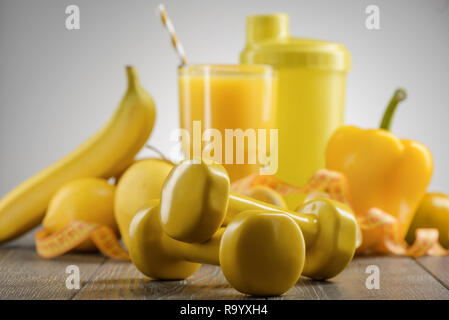 Fruta en un vaso, una campana y una cinta para medir el cuerpo