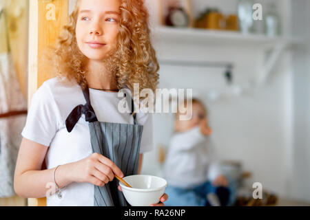 Lindo joven chica y su hermana niño prepara el desayuno para los padres. Foto de stock