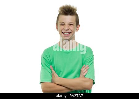 Niña feliz sonriente con las manos cruzadas en camiseta verde aislado sobre  fondo blanco.