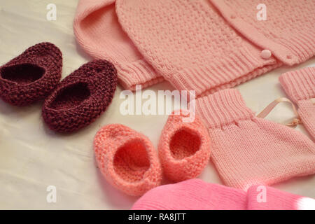 interno Colega sofá Hermosos tejidos de lana zapatos para bebés pequeños pies y rosa vestido de  bebe Fotografía de stock - Alamy