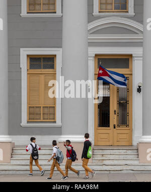 Los colegiales caminando delante del Colegio San Lorenzo, la Plaza José Martí, Cienfuegos, Cuba Foto de stock