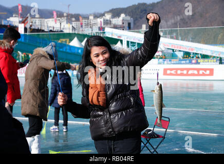Hwacheon, Corea del Sur. 5 de enero, 2019. Una mujer muestra una trucha ella atrapada en un río congelado durante el Festival de hielo Sancheoneo de Hwacheon, Corea del Sur, el 5 de enero de 2019. Como uno de los mayores eventos de invierno en Corea del Sur, el anual Festival de tres semanas atrae a la gente a los congelados Hwacheon River, en donde los organizadores de pesca taladrar agujeros en el hielo y la liberación de truchas en el río durante el periodo que dura el festival. Este año el festival dura desde el 5 de enero al 27 de enero. Crédito: Wang Jingqiang/Xinhua/Alamy Live News Foto de stock