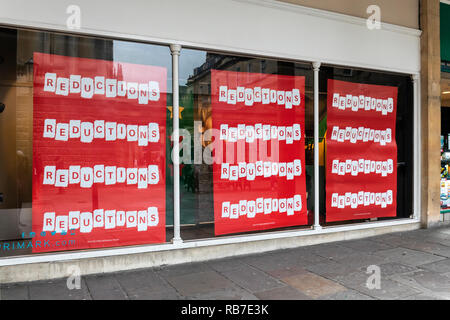Reducciones rojo publicidad firme de venta en una tienda Primark, Bath, Reino Unido