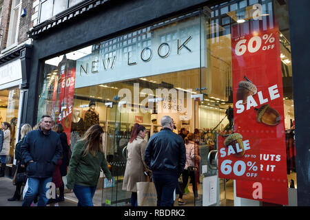 Los compradores de Chester pasaba por la sucursal de Nueva apariencia con carteles de "Se vende" en la ventana Foto de stock