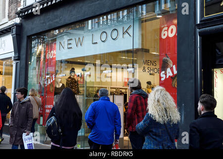 Los compradores de Chester pasaba por la sucursal de Nueva apariencia con carteles de "Se vende" en la ventana Foto de stock
