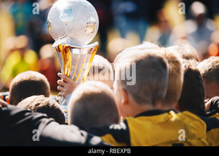 Los niños Sport Team con el trofeo. Los niños celebrando el campeonato de fútbol. Feliz jóvenes futbolistas la celebración de la Copa de Oro. Equipo de Fútbol Fútbol Juvenil ganadora