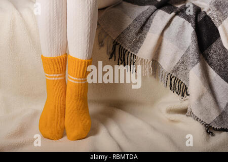 Piernas femeninas blanco cálido tejidas medias y de color amarillo sobre fondo blanco hecha de piel falsa Fotografía de stock - Alamy
