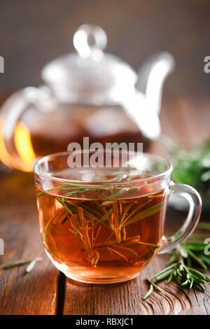 Té de romero en vidrio taza de té sobre la mesa de madera rústica closeup. Vitamina té de hierbas.