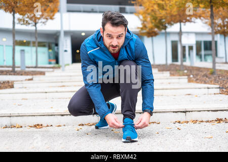 Hombre deportivas de cordones de zapatillas de deporte hasta antes de la  sesión de formación Fotografía de stock - Alamy