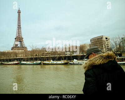 París, Francia - Jan 30, 2018: Parisian altos hombre mira la crecida del río Sena, cerca de la Torre Eiffel como el desbordamiento de los diques del río después de días de Heavy Rain Foto de stock