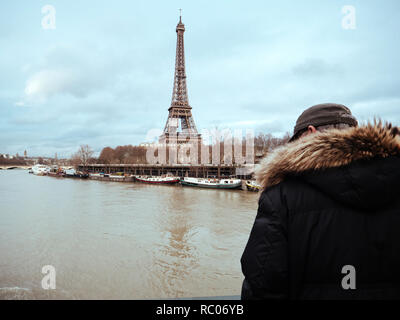 París, Francia - Jan 30, 2018: Parisian altos hombre mira la crecida del río Sena, cerca de la Torre Eiffel como el desbordamiento de los diques del río después de días de Heavy Rain Foto de stock
