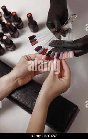 La mano maestra de manicura está sacando la herramienta de aerógrafo para  uñas usando guantes blancos de la caja Fotografía de stock - Alamy