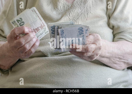 Closeup arrugadas manos de mujer mayor contando dinero (lira turca) Foto de stock