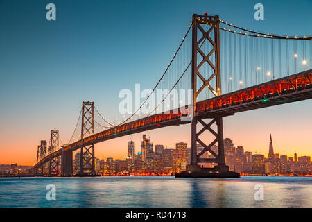 Classic vistas panorámicas del horizonte de San Francisco con el famoso Puente de la Bahía Oakland iluminado en la hermosa luz del atardecer dorado al atardecer en verano Foto de stock