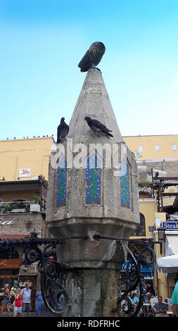 Hipócrates la plaza con su fuente con th eowl de Minerva sentado en la parte superior de la ciudad amurallada de Rodas, en las islas del Dodecaneso Foto de stock
