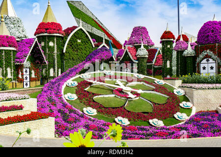 Dubai, Emiratos Árabes Unidos 11. 06. 2018 : Reloj Floral brillante con pequeño jardín casas en el Milagro Jardín en Dubai