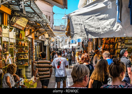 Atenas, Grecia - 22 de septiembre de 2018: los turistas recorren las calles alineadas con tiendas de recuerdos y cafeterías en la turística Plaka de Atenas, Grecia