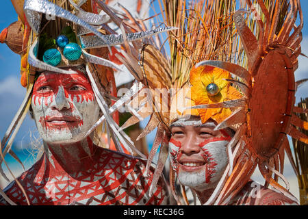 Dos jóvenes varones residentes locales se une al desfile Ati-Atihan en coloridos trajes diseñados a lo largo de la playa blanca en la isla de Boracay, municipio de