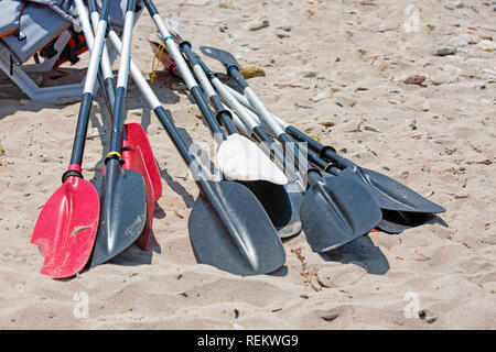 Bote remos tumbarse en la arena de la playa por el mar Foto de stock