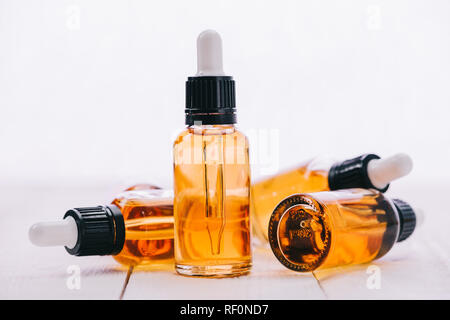 El cannabidiol aceite en botellas con cuentagotas sobre la superficie de madera con copia espacio aislado en blanco Foto de stock