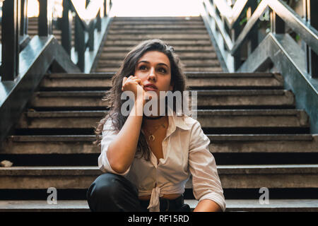 Retrato de mujer joven sentada en las escaleras