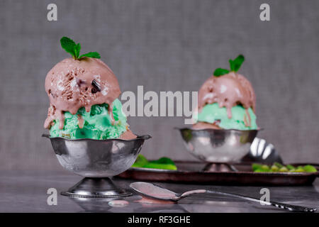 Selección de pistachos y helado de chocolate cucharas con decoraciones Foto de stock