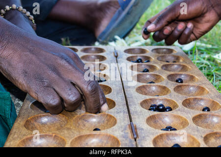 Dos hombres jugando un juego llamado Igisoro Local, en Rwanda, África Oriental