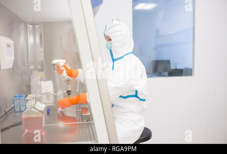 Técnico de laboratorio usando cleanroom trabajan en general cuadro laminar estéril