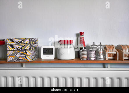 Diversos accesorios de mesa y cocina en un estante encima de un radiador  Fotografía de stock - Alamy