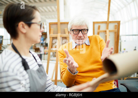 Retrato de escandalizado profesor de arte mirando estudiante haciendo bocetos durante el taller, espacio de copia
