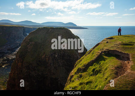 Persona en la cima de los acantilados del mar, cerca de los Campos de Ceide, Condado de Mayo, Irlanda del Norte.