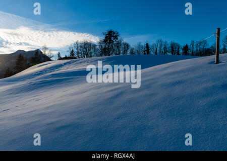 Últimos rayos de sol sobre un Campo de Nieve en Bayrisch Gmain, Baviera, Alemania Foto de stock