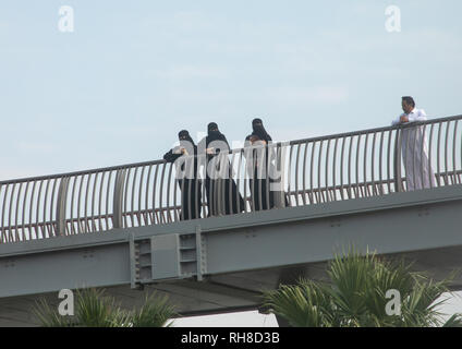 Las mujeres saudíes en niqabs mirando a través de un puente, provincia de La Meca, Jeddah, Arabia Saudita Foto de stock