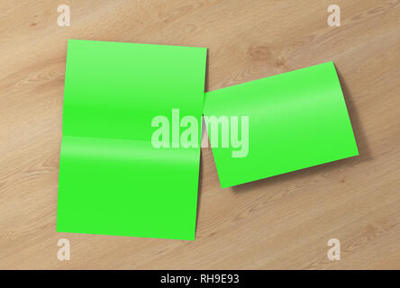 Verde en blanco abierto y plegado medio plegado folleto volante sobre fondo de madera. Con trazado de recorte alrededor del folleto Foto de stock