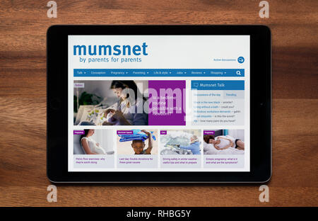 El sitio web de Mumsnet es visto en un iPad, que descansa sobre una mesa de madera (uso Editorial solamente). Foto de stock