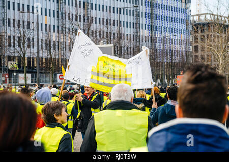 Estrasburgo, Francia - Feb 02, 2018: la gente demostrando marchando con pancartas durante la protesta de Gilets Jaunes chaleco amarillo pancarta con la inscripción Macron renuncia