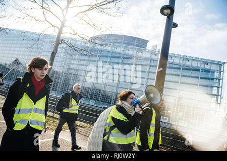 Estrasburgo, Francia - Feb 02, 2018: la mujer gritando en Altavoz megáfono demostrando marchando con pancartas durante la protesta de Gilets Jaunes chaleco amarillo manifestación Parlamento Europeo