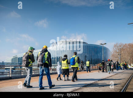 Estrasburgo, Francia - Feb 02, 2018: la gente demostrando caminando hacia el Parlamento Europeo durante la protesta de Gilets Jaunes chaleco amarillo manifestación manifestaciones antigubernamentales